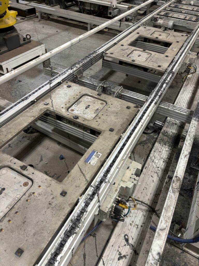Automotive conveyor line and pallet fixtures coated in adhesive and sealer residue before dry ice blasting, Windsor plant